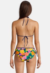 Bikini multicolore avec motif floral ; design à col halter avec liens, associé à un bas à nouer sur les côtés aux couleurs tropicales vives.