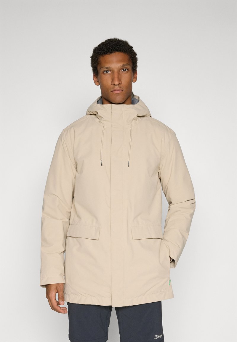 Beige waterdichte jas met capuchon, voorzien van voorzakken en koordjes. Glad oppervlak, rechte snit, geschikt voor buitenactiviteiten.