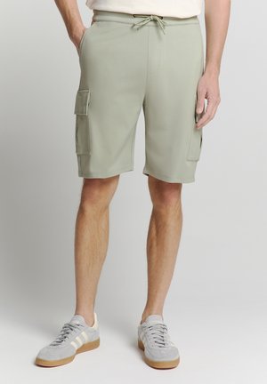 Lichtgroene cargoshorts met een elastische tailleband en koord. Voorzien van twee zijzakken en twee cargozakken op de dijen.