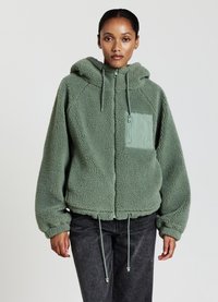 Giacca in pile verde con un esterno testurizzato, tasca sul petto con zip, cordini regolabili all'orlo e cappuccio accogliente.