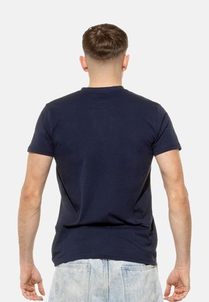 Navy blue cotton t-shirt with a crew neckline and short sleeves, smooth texture, fitted design, viewed from the back.
