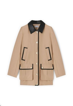 Hellbeige Jacke mit schwarzem Lederkragen und -besatz, ausgestattet mit zwei Fronttaschen mit Klappen und Druckknöpfen. Glatte Textur.