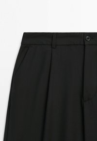 Black tailored trousers with belt loops, button closure, front pleats, and side pockets on a white background.