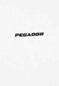 Hvid bomuldsstof med en glat overflade, der har det broderede sorte ord "PEGADOR" centreret nederst.