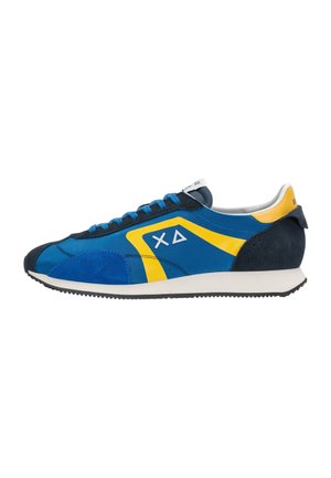 Scarpa da ginnastica azzurra e gialla con suola bianca, tacco e punta in camoscio blu navy, lacci blu e logo geometrico bianco sul lato.