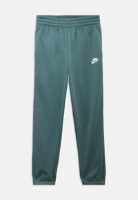 Grønne treningsbukser med elastisk midjebånd, innsnevrede mansjetter og en hvit Nike-logo på venstre lår. Laget av mykt, glatt stoff.