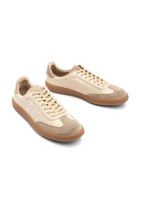 Baskets basses en cuir et daim beige avec semelles en caoutchouc couleur fauve, fermeture à lacets et détail du logo cousu sur le côté.