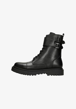 Schwarze Leder-Stiefeletten mit rundem Zehenbereich, Schnürverschluss vorne und zwei verstellbaren Riemen mit Schnallen. Robuste Sohle für Haltbarkeit und Griffigkeit.