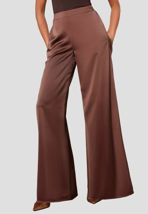 Pantalons larges en satin marron avec une texture lisse, dotés de poches latérales et d'une taille haute, sur un fond neutre.