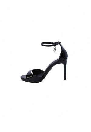 Sandal con tacco alto in vernice nera, con cinturino alla caviglia regolabile, punta aperta e tacco curvo, dotata di un piccolo charm decorativo.