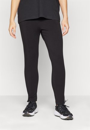 Sorte leggings med en tettsittende design, glatt tekstur, og ingen synlige mønstre. Brukt sammen med sorte treningsko for kontrast.