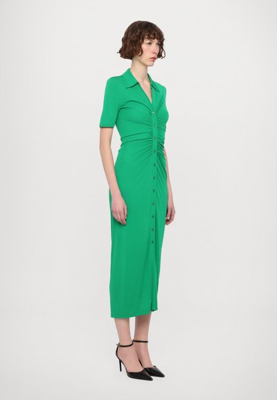 Vestido verde hasta la rodilla con mangas cortas, cintura ajustada y botones en la parte delantera. Hecho de tela suave con una textura sutil.