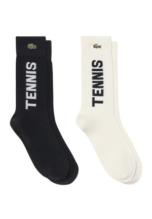 Coppia di calzini crew bianco e nero con la parola "TENNIS" stampata verticalmente e un piccolo logo coccodrillo vicino al bordo.