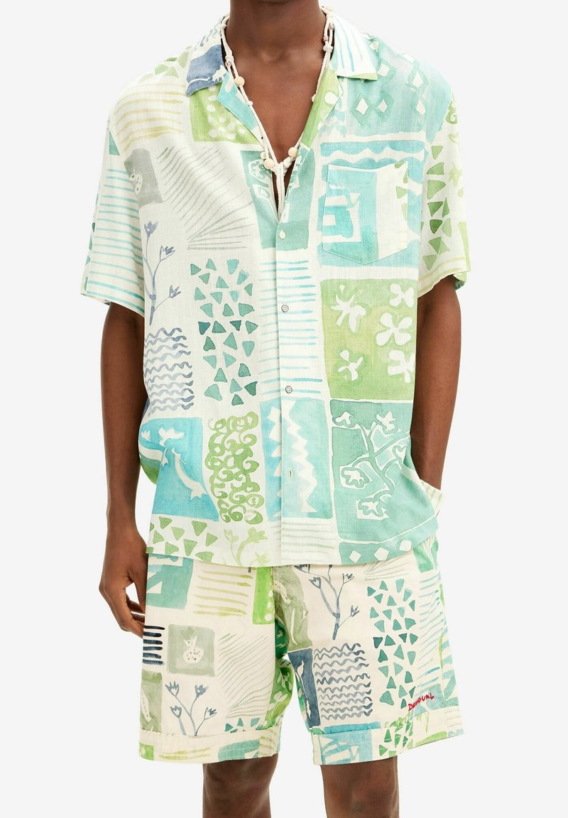 Set van kortærmelig overhemd en korte broek in licht linnen, met groene en blauwe patronen, geometrische vormen en grafische bloemmotieven.