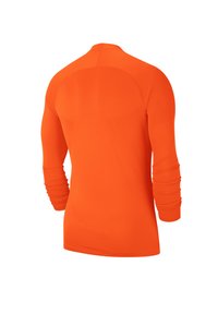Camicetta a maniche lunghe di un vivace arancione, realizzata in tessuto liscio e leggero. Presenta maniche raglan e un pannello testurizzato sul retro.