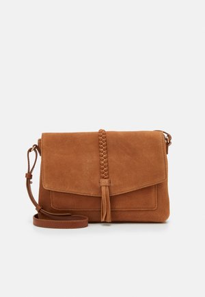 Brązowa zamszowa torba na ramię z plecionym detalem w postaci frędzli i regulowanym skórzanym paskiem na białym tle.