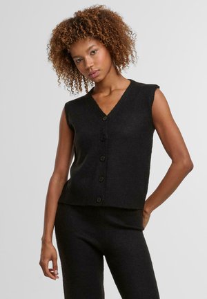 Schwarze Strickweste ohne Ärmel mit V-Ausschnitt, mit fünf Knöpfen auf der Vorderseite. Weicher Stoff und enganliegendes Design.