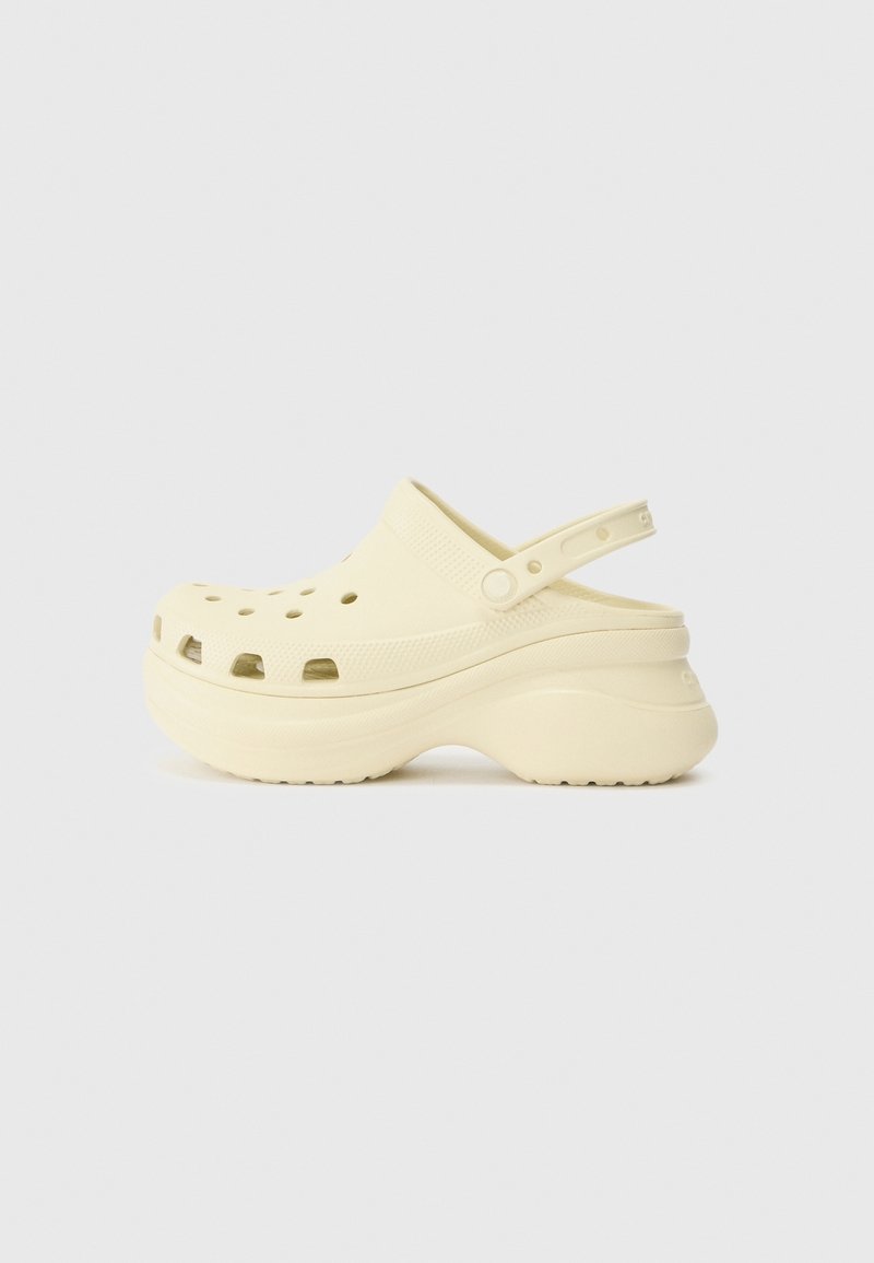 Sabot à plateforme beige clair avec des trous de ventilation, bride de talon ajustable et semelle texturée pour une meilleure adhérence, présenté de profil.