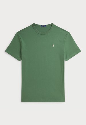 Grön bomullströja med rund hals och korta ärmar. Har en liten broderad logotyp i vitt på vänster bröst.