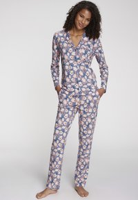 Blüten-Pyjama-Set mit einem knöpfbaren Oberteil und langen Hosen. Aus weichem Stoff gefertigt, mit blauer Hintergrundfarbe und pinkem Blumenmuster.