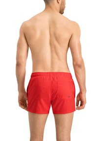 Rote Badehose aus leichtem Material. Verfügt über einen elastischen Bund und eine Gesäßtasche mit Logo. Schlichtes, tailliertes Design.