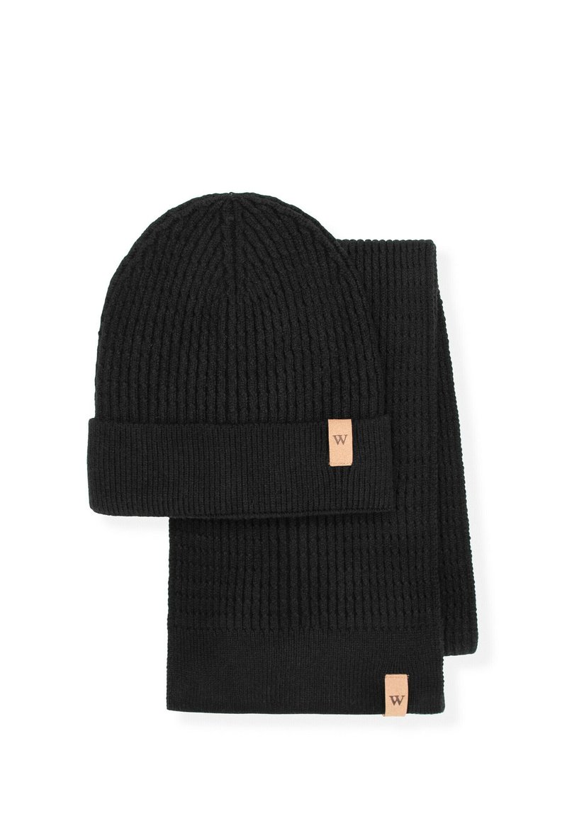 Czarny prążkowany zestaw czapki i szalika z dzianiny, złożony z czapki z podwiniętym mankietem i gładką fakturą, oba z małym skórzanym logo.