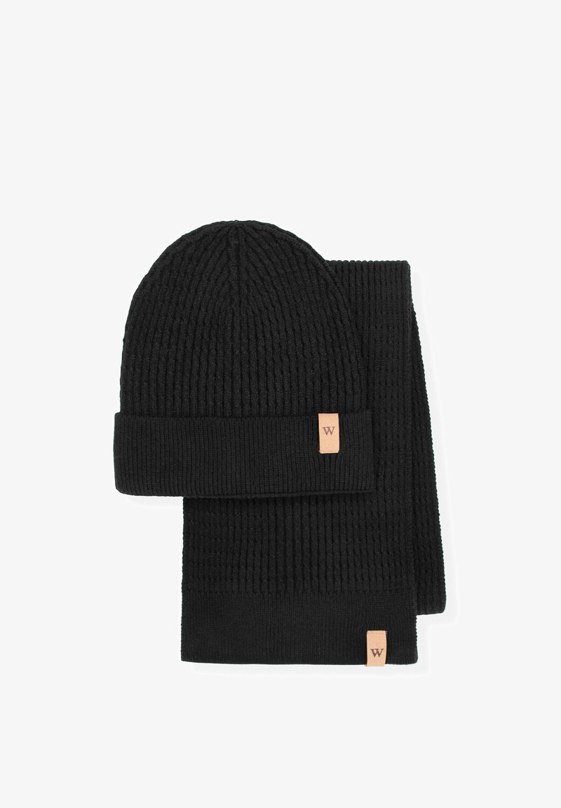 Zwart geribbelde grofgebreide muts en sjaal set, met een omgeslagen boord aan de muts en een gladde textuur, beide voorzien van een klein leren logobedrukking.