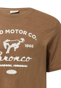 Brązowa koszulka z białym napisem "Ford Motor Co. 1966 Bronco Dearborn, Michigan" oraz grafiką białego konia.
