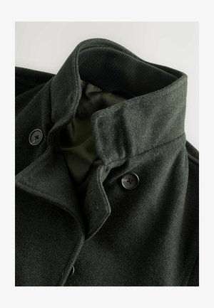 Tume roheline villa segu mantel kõrge kraega, mustade nuppudega ja sileda sisemise voodriga. Tekstureeritud kangas pehme viimistlusega.