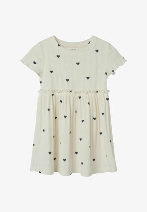 Jasna kremowa sukienka z krótkimi falbanowymi rękawami, teksturowany materiał i rozproszone czarne serca. Pas zebranie elastyczne.