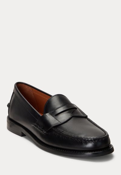 Juodi odiniai loaferiai su pinigų dirželiu, apvaliu pirštu ir žemu kulnu, rodomi ant balto fono, šiek tiek pasvirę į dešinę.