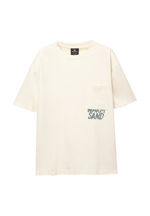 T-shirt a maniche corte di cotone color crema con taschino sul lato sinistro del petto e la scritta "WARM SAND" stampata in teal sul davanti.