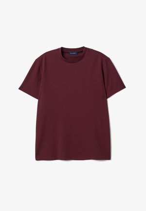 Maglietta bordeaux a maniche corte con scollo rotondo e etichetta all'interno del collo, distesa su sfondo bianco.