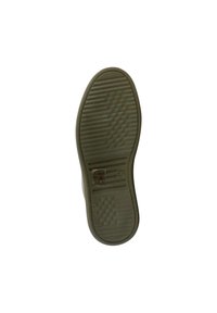 Green rubber shoe sole featuring textured grip patterns, smooth areas, and a logo imprint near the heel. Rounded toe and curved edges.