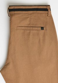 Brązowe bawełniane spodnie z czarnym paskowanym pasem, z tylną kieszenią i małą metką z logo na tkaninie.