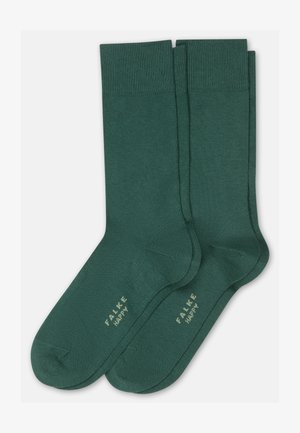 Paar dunkelgrüne, knielange Socken mit gerippten Bündchen, nahtlosen Zehenbereichen und dem Aufdruck "FALKE HAPPY" in Hellbeige im Fußbereich.