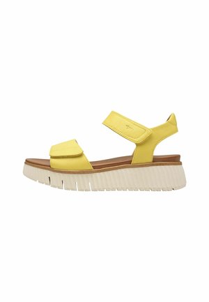 Sándala de cuero amarillo con dos correas ajustables, suela de plataforma blanca texturizada y plantilla acolchada para mayor comodidad.