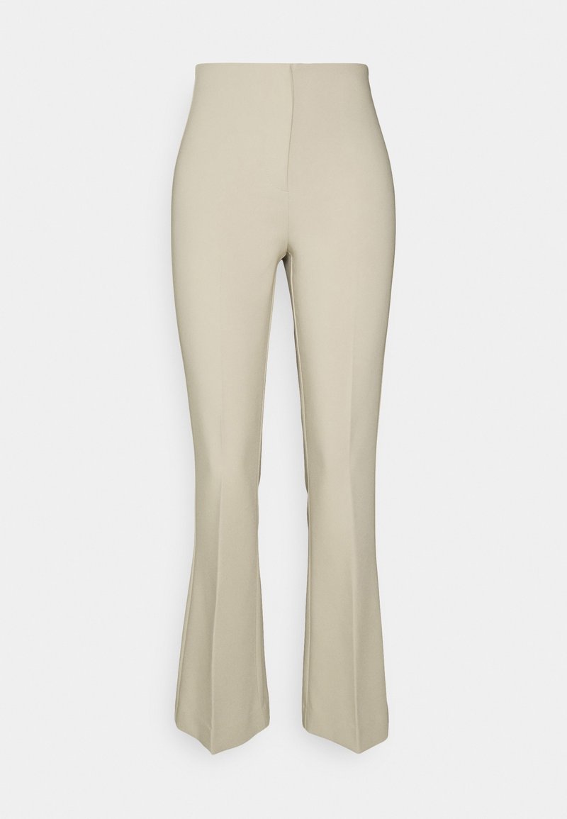 Pantalon beige taille haute avec une jambe haute ajustée et une jambe basse évasée, à l'avant lisse sans poches visibles ni ornements.