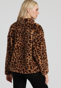 Leopardprint faux fur jakke med en hyggelig krave, lange ærmer og en afslappet pasform. Brun og sort mønster på blød, tekstureret stof.