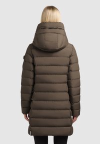 Brun pufferjakke med hætte, der har vandrette quiltede sektioner, glat tekstur og sorte hardware-detaljer.