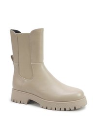 Cizme bej până la gleznă din piele netedă, cu panouri elastice pe laterale, talpă groasă tip lug și design cu vârf rotund.