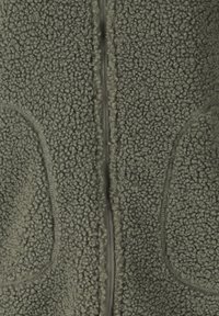 Oliivinvihreä fleecekangas, jossa on tiheä kihara rakenne ja keskellä näkyvä pystysuora vetoketju, sivuilla pyöristetyt saumalistat.