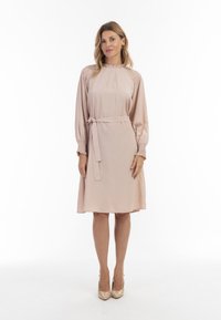 Rochie roz deschis cu guler înalt, mâneci lungi �și puffate, și o talie ajustată cu un cordon. Material neted cu detalii plisate la umeri.