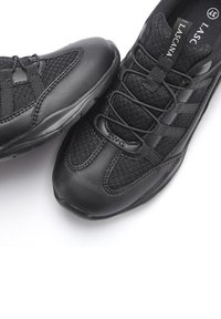 Scarpe atletiche nere con una combinazione di pelle liscia e rete testurizzata. Presentano lacci, cinghie incrociate e una suola in gomma.