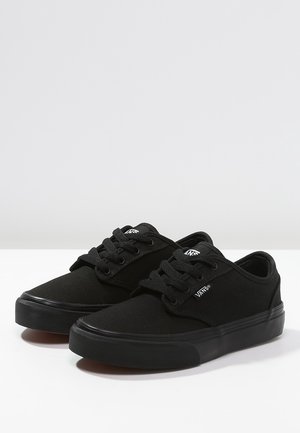 Sorte kanvas sneakers med rund tå, gummisål og seks snøreøjer. Har et diskret logo på siden og tekstureret stof.