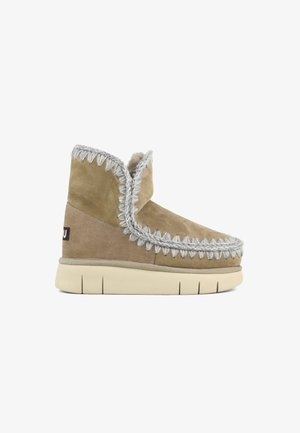 Botas de ante color topo hasta el tobillo con ribete gris, que presentan un diseño de costura texturizada, una puntera redondeada y una suela gruesa y acolchada para mayor comodidad.
