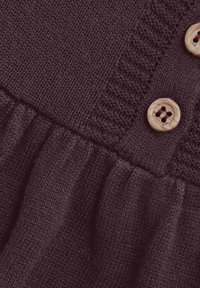 Dunkelviolettes gestricktes Kleidungsstück mit strukturiertem Oberteil und gerafftem Saum, akzentuiert mit Holzknöpfen. Weicher Stoff mit feiner Musterung.