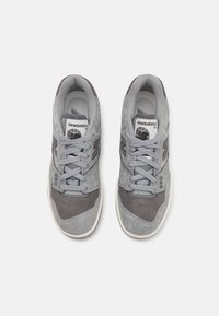 Grå suede sneakers med strukturerte detaljer, med lys grå lisser og en hvit gummisåle. Inkluderer merking på tungen og siden.