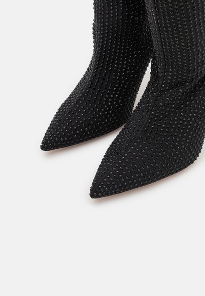 Black fabric ankle boots with pointed toes, embellished with small black studs, featuring a fitted design and smooth texture.