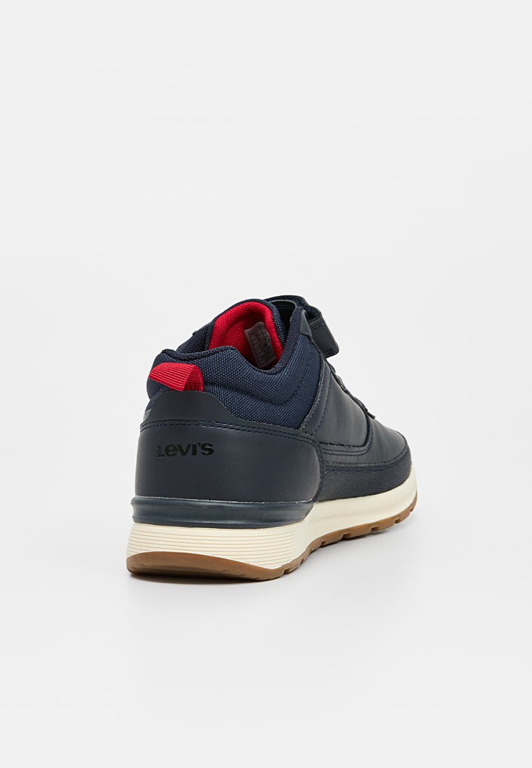 Zapatos deportivos azul marino con tela texturizada y acentos de cuero. Suela beige y detalle en el talón rojo. Logo de Levi's en la parte trasera.